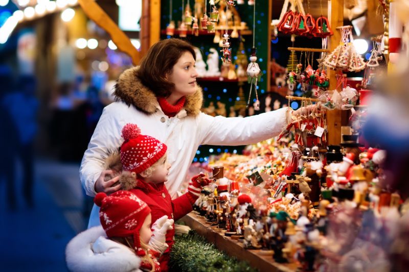 A mom and her daughter at christmas market winter fair